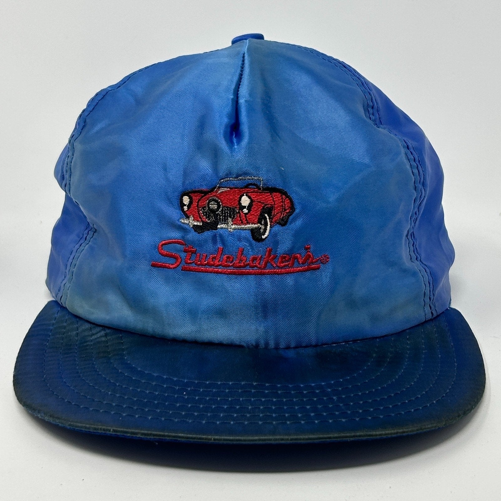 Front view of a blue Vintage Hat featuring embroidered Studebaker logo and classic car design