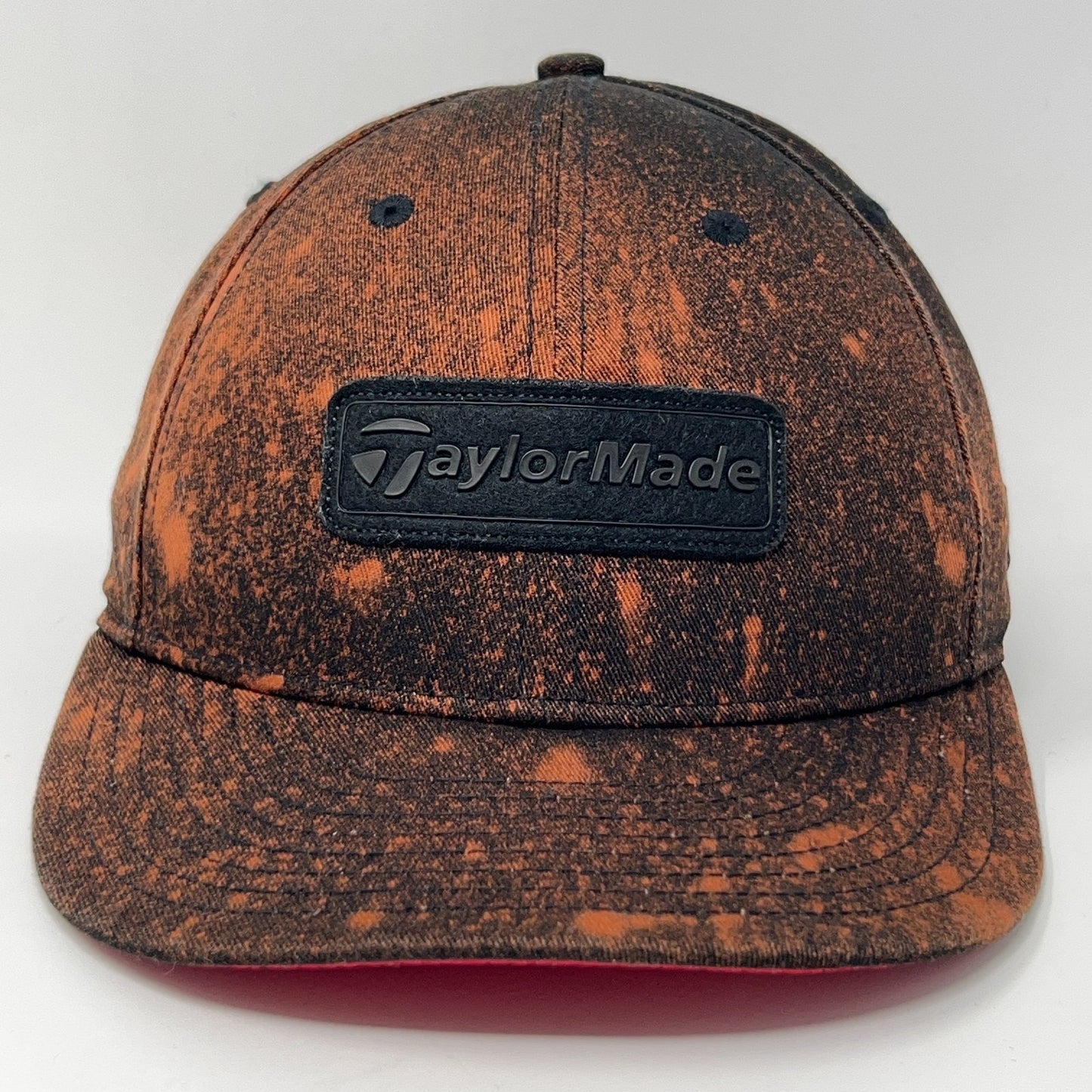 Front view of TaylorMade baseball cap hat in orange and black with logo and distressed finish