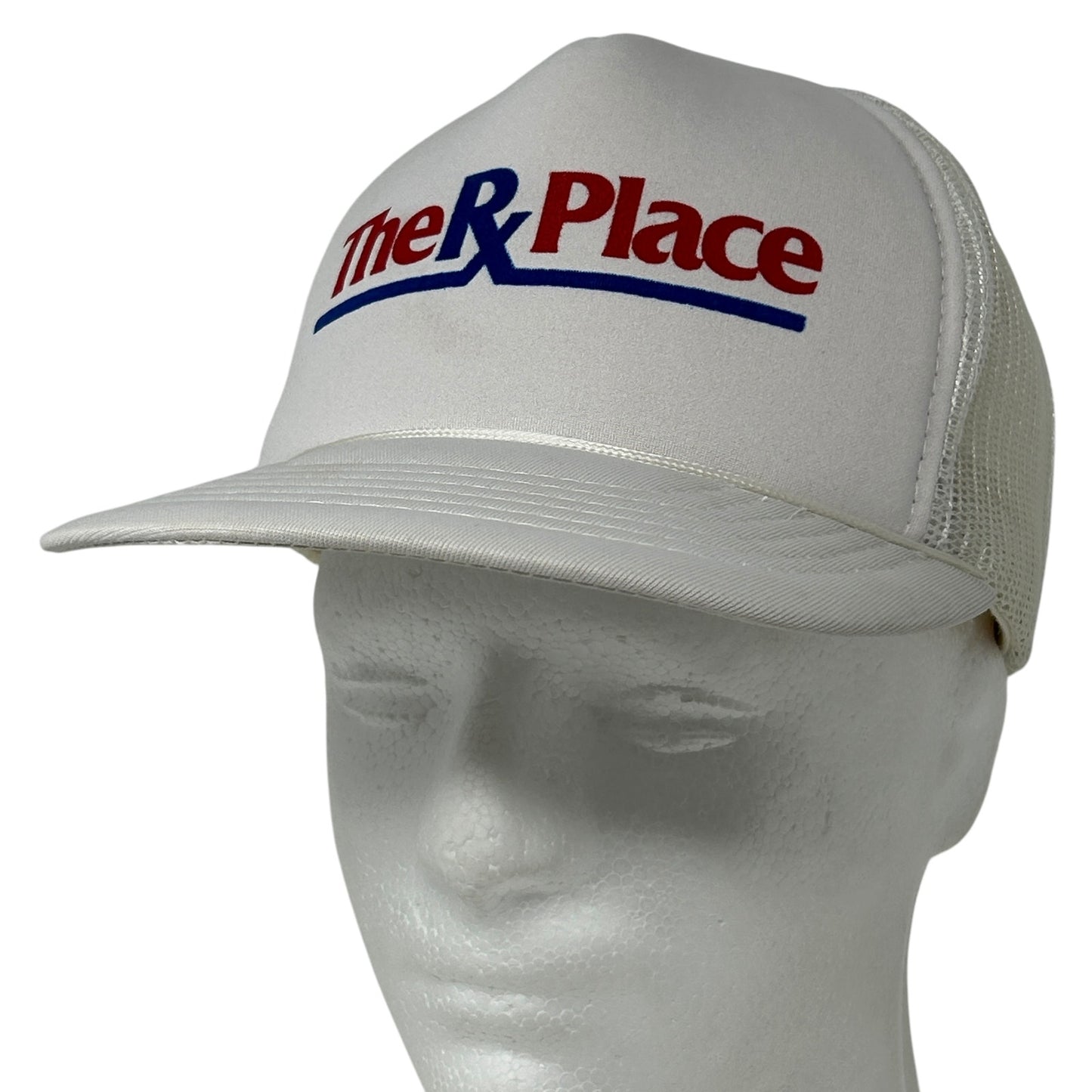 White Yupoong hat featuring The RX Place Drug Store logo on the front, mesh back design for breathability