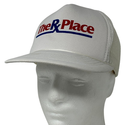 White Yupoong hat featuring The RX Place Drug Store logo on the front, mesh back design for breathability