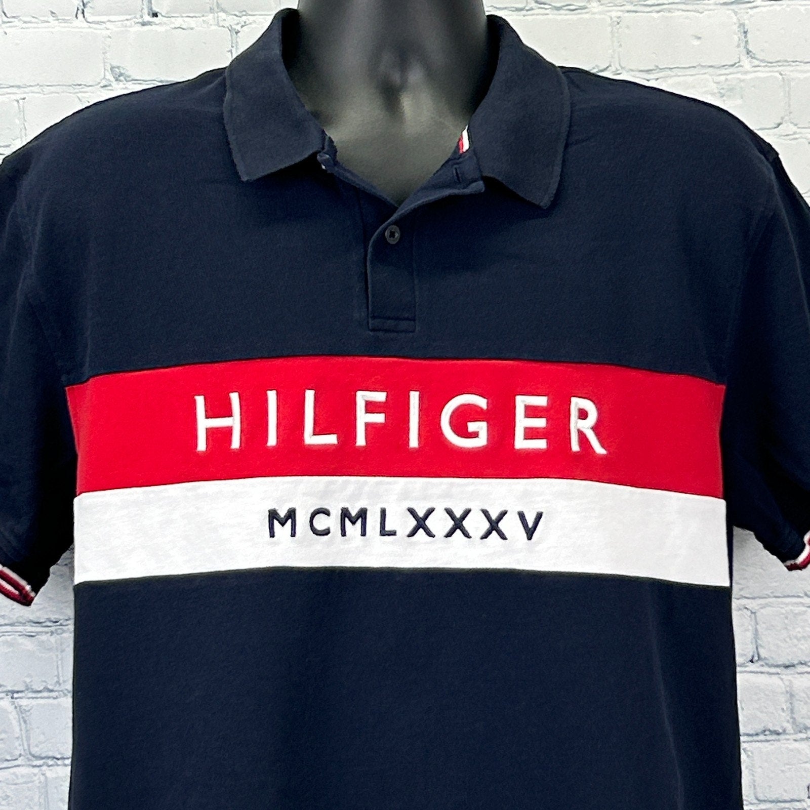 Tommy Hilfiger Polo in navy blue with red and white stripes, featuring a logo across the chest, front view