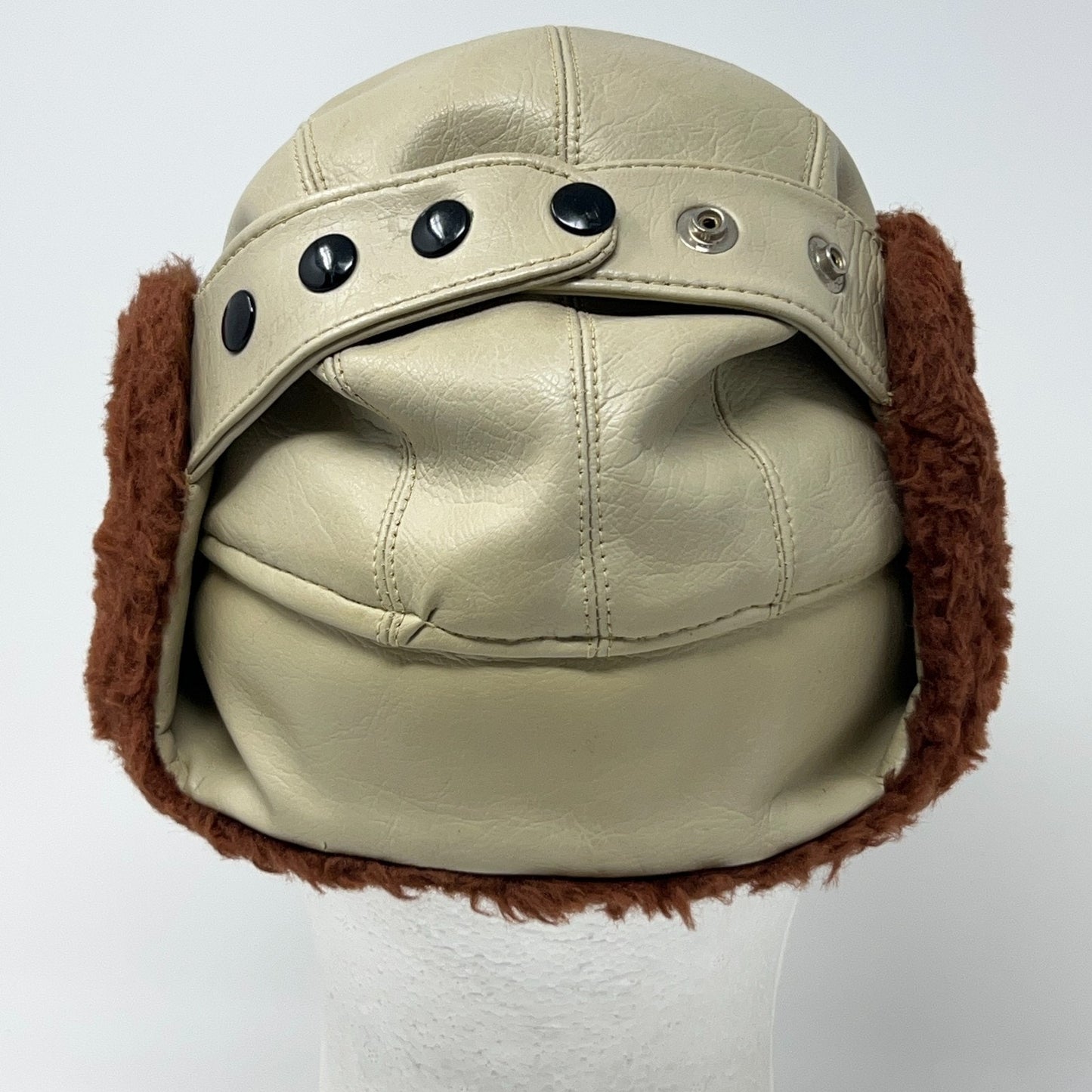 Vintage 1980s beige trapper hat with brown faux fur ear flaps and black buttons, rear view