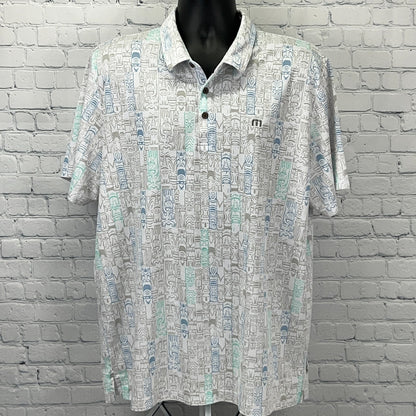 Travis Mathew short-sleeve polo shirt in white with a colorful geometric pattern, featuring logo on chest