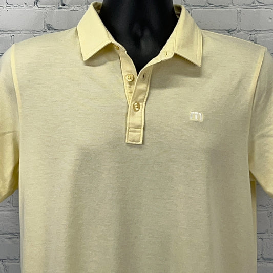 Travis Mathew Polo in light yellow, size medium, featuring a classic fit and embroidered logo on the chest
