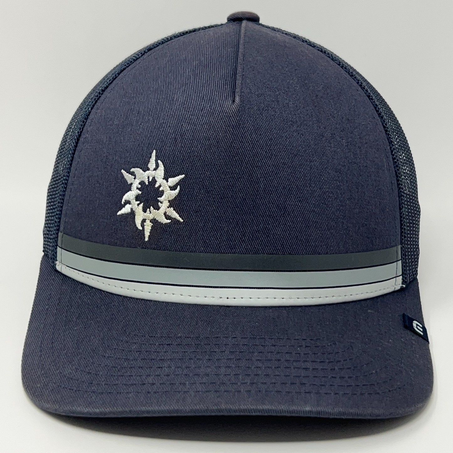 Travis Mathew Spanish Trail navy baseball cap with embroidered logo and gray striped detail on the front