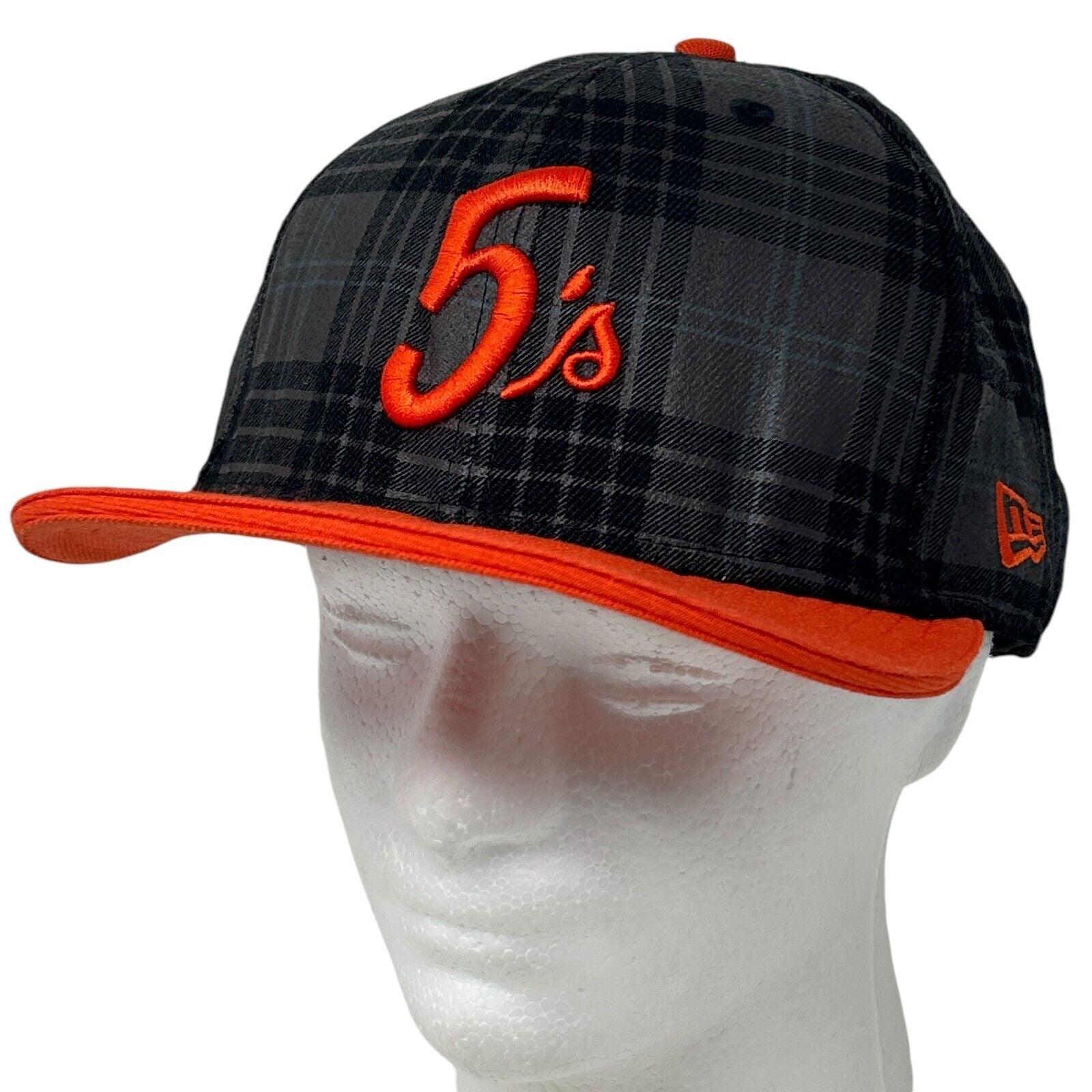 New Era Undefeated black and orange plaid cap with '5's' embroidered on the front