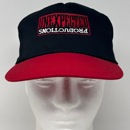 Front view of black and red Vintage hat with Unexpected Productions logo embroidered on the front