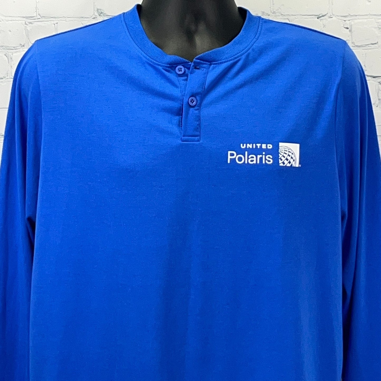 Blue long-sleeve shirt featuring United Polaris logo, front view with button detail
