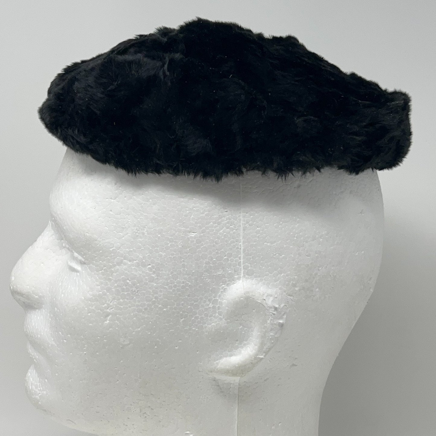 Saks Fifth Avenue pillbox hat in black vintage style viewed from the side on a mannequin head