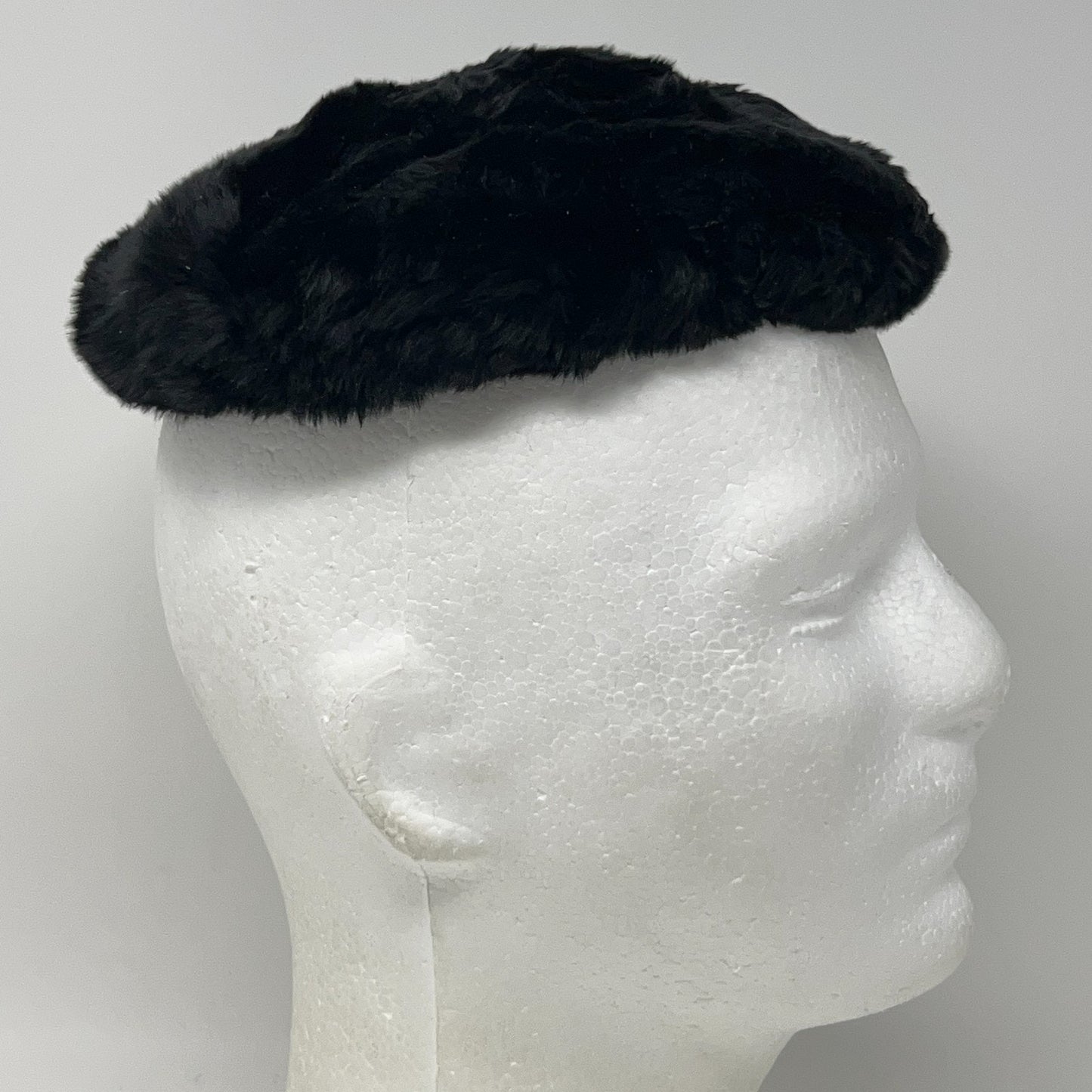 Saks Fifth Avenue vintage black pillbox hat displayed on a mannequin head, side view