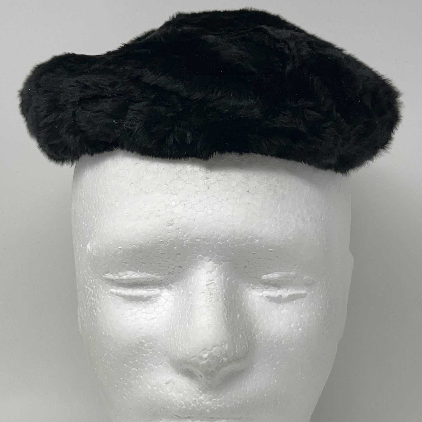 Saks Fifth Avenue black pillbox hat from the 1960s, shown from the front on a mannequin