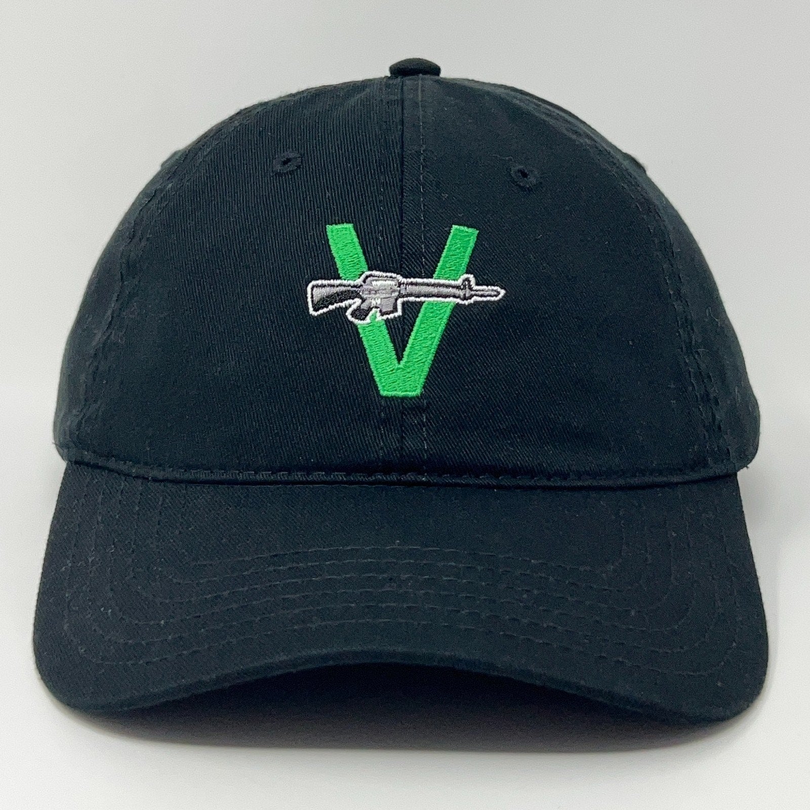 Black cap with green V logo and rifle embroidery, front view, by The Vandals