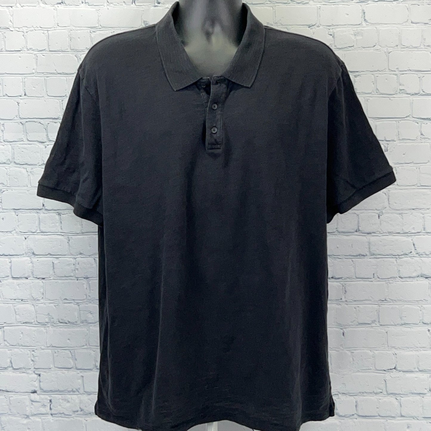 Vince Polo in black, featuring a classic fit and three-button placket, front view on a mannequin