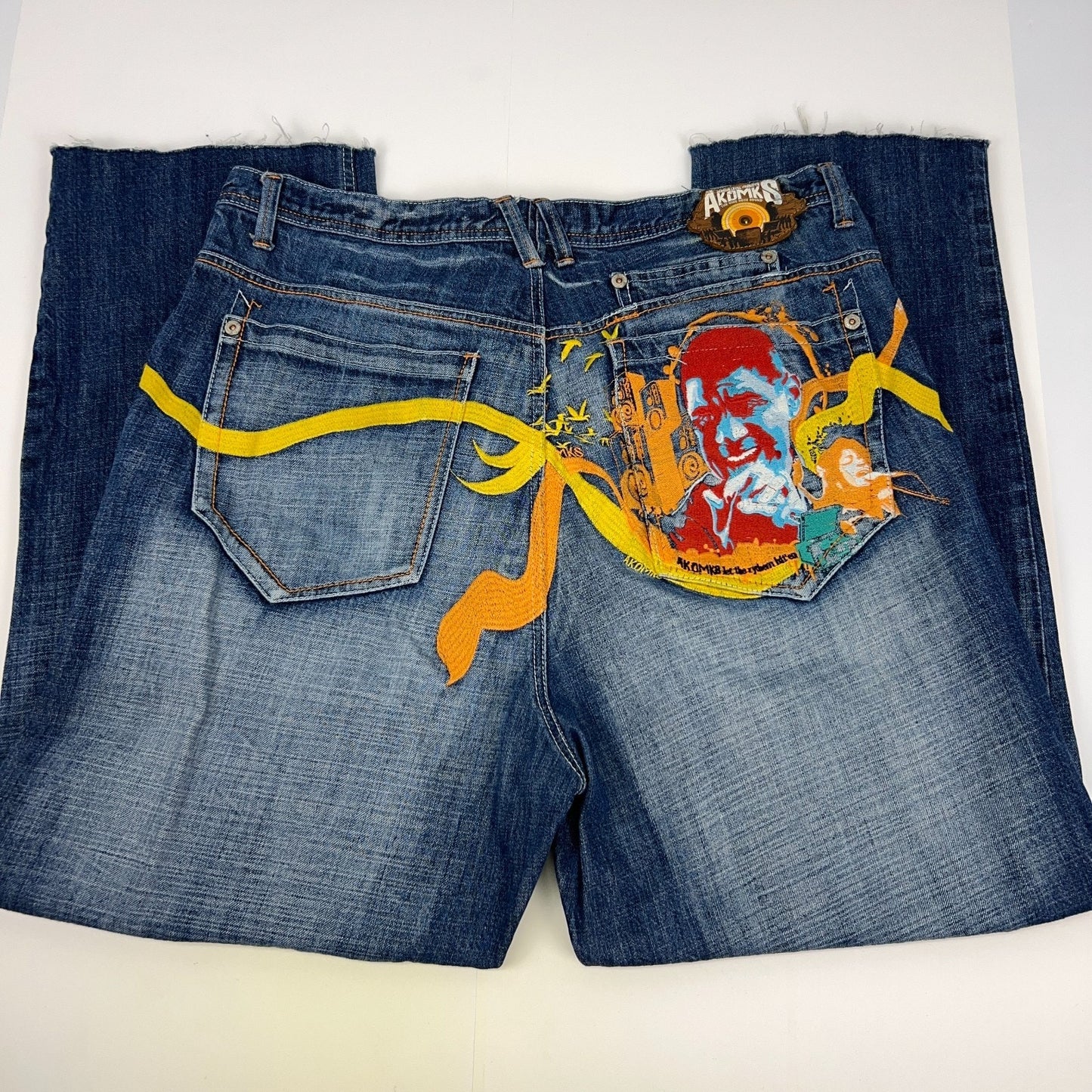 Akademiks 2000s vintage denim jeans in blue, size 34, back view with unique graphic design
