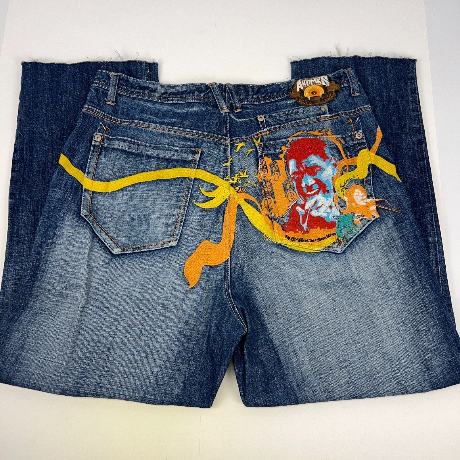 Akademiks 2000s vintage denim jeans in blue, size 34, back view with unique graphic design