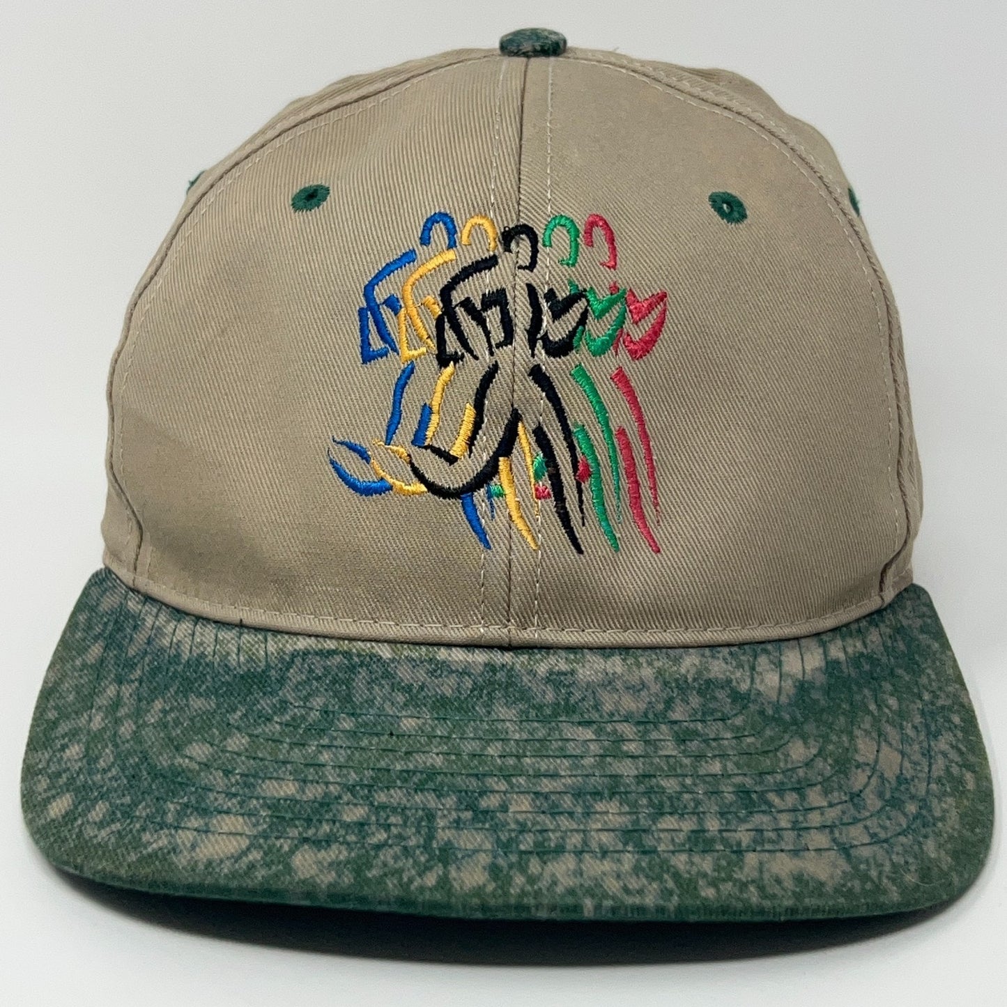 Vintage beige baseball hat featuring colorful Olympics logo with a green speckled brim