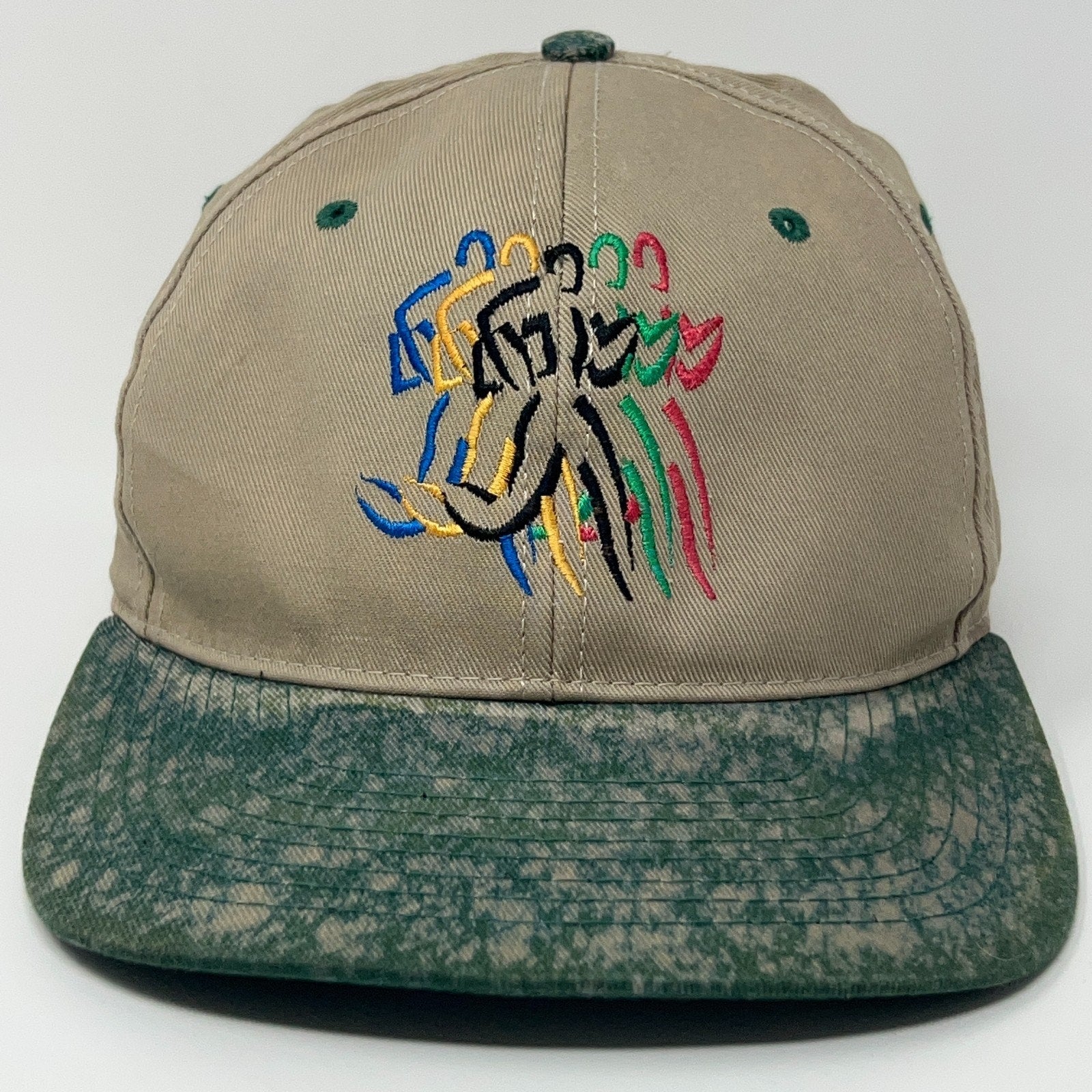 Vintage beige baseball hat featuring colorful Olympics logo with a green speckled brim