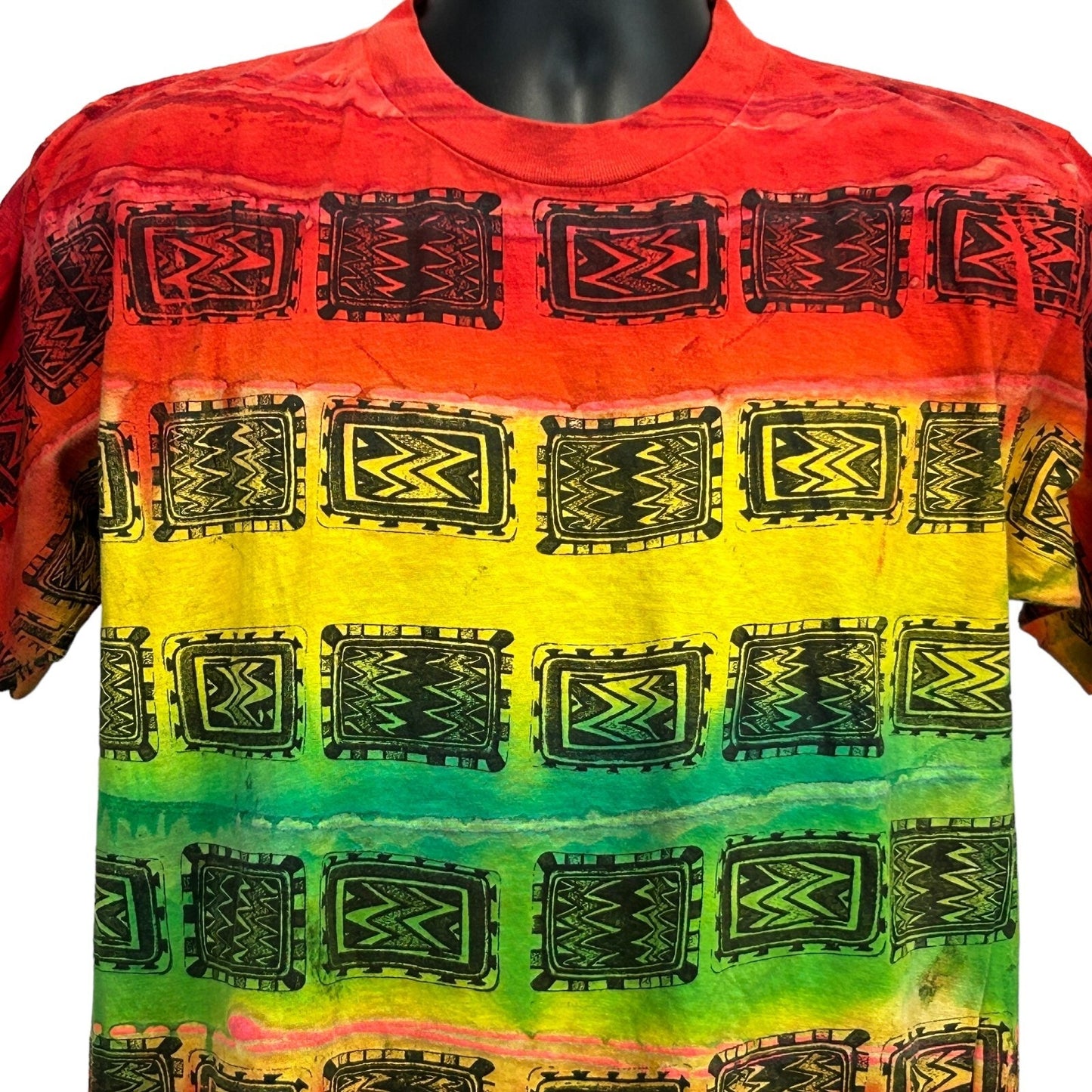 Front view of a Vintage T Shirt with a vibrant red, yellow, green, and black tribal pattern in size large