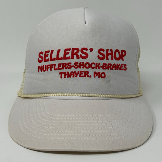 Front view of a vintage trucker hat in white with red 'SELLERS' SHOP MUFFLERS-SHOCK-BRAKES THAYER, MO' text