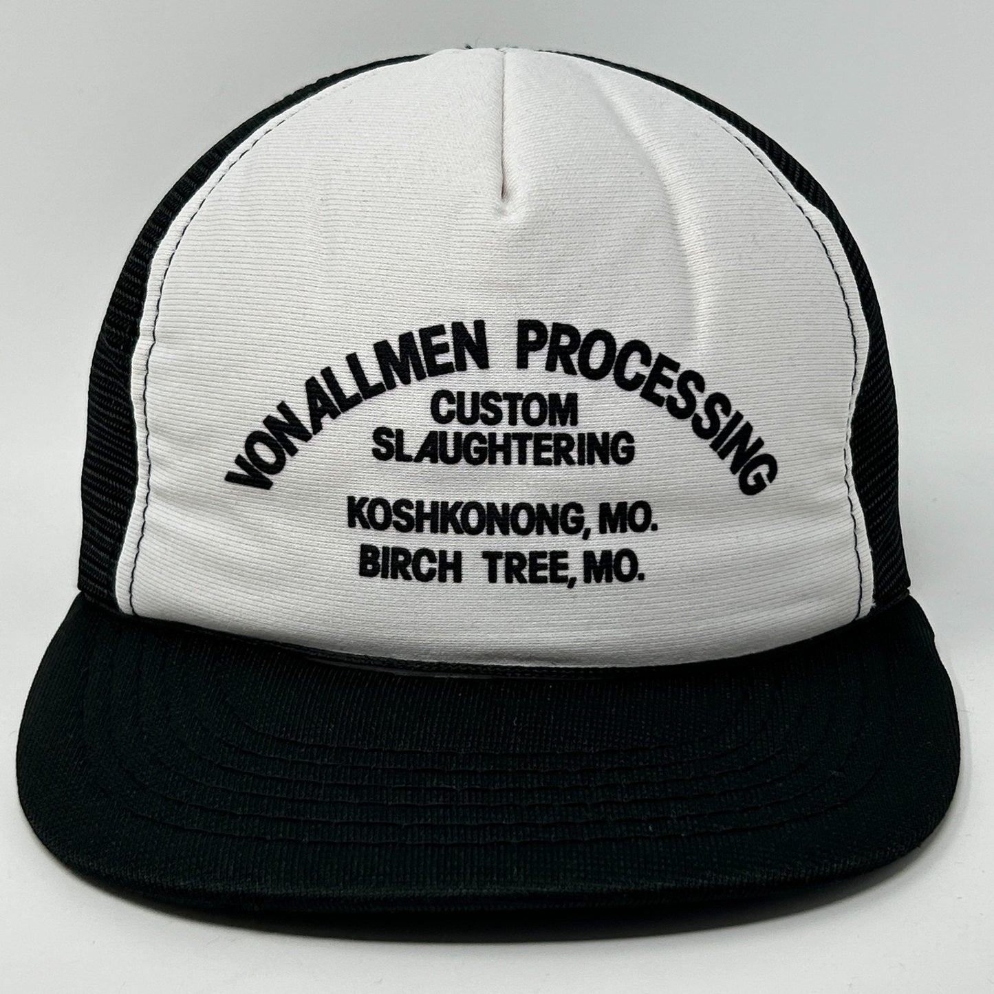 Front view of a Vintage Trucker Hat featuring a white and black design with custom logo text