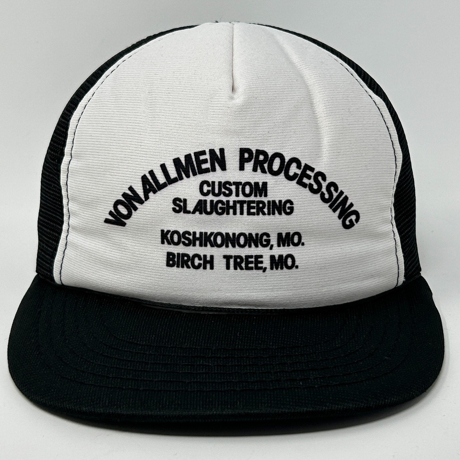 Front view of a Vintage Trucker Hat featuring a white and black design with custom logo text