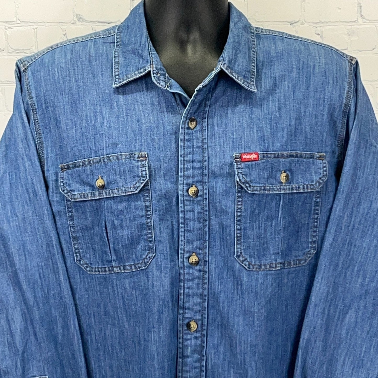 Front view of Wrangler denim shirt in blue with two chest pockets and a classic fit