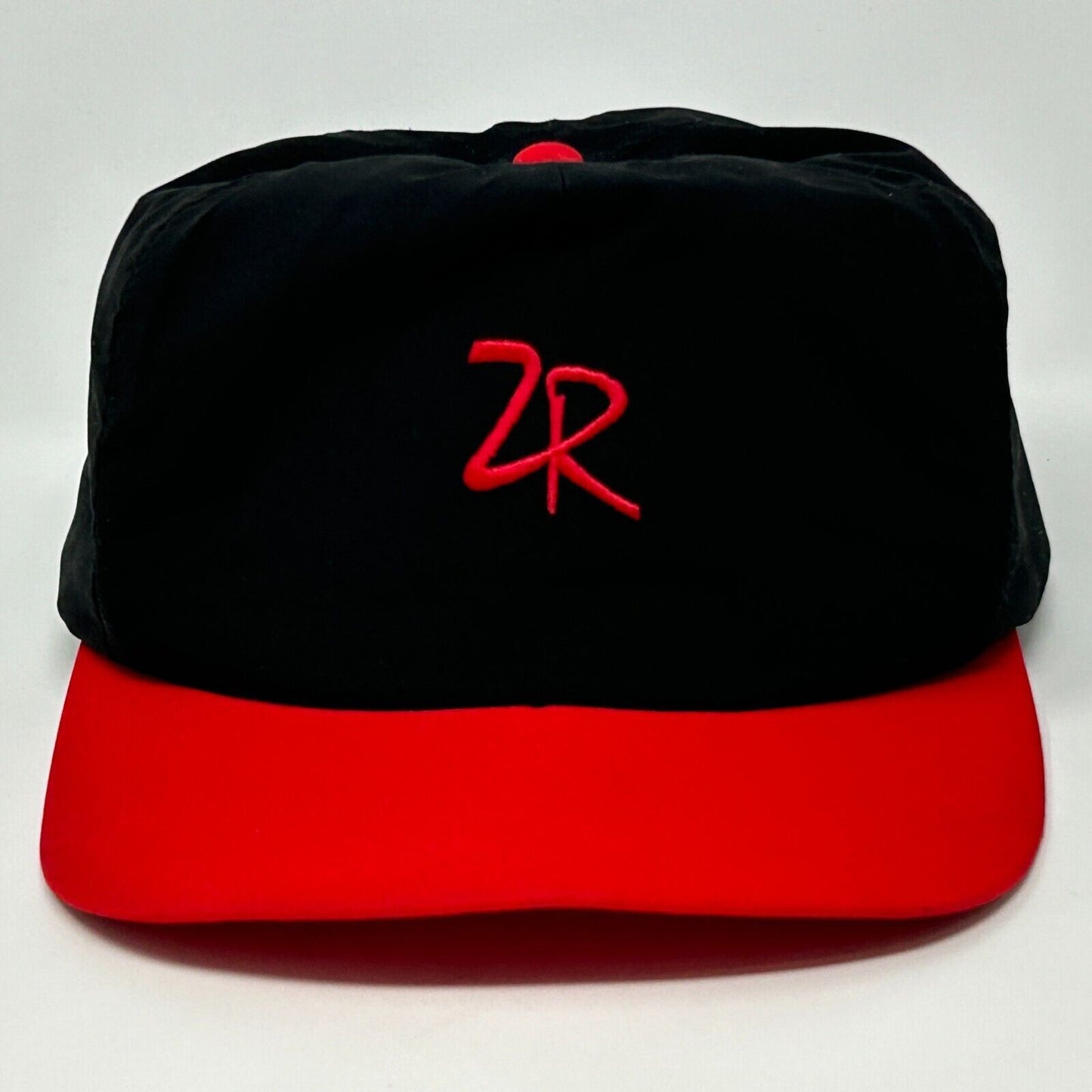 Front view of Zero Restriction black and red cap featuring a red embroidered logo